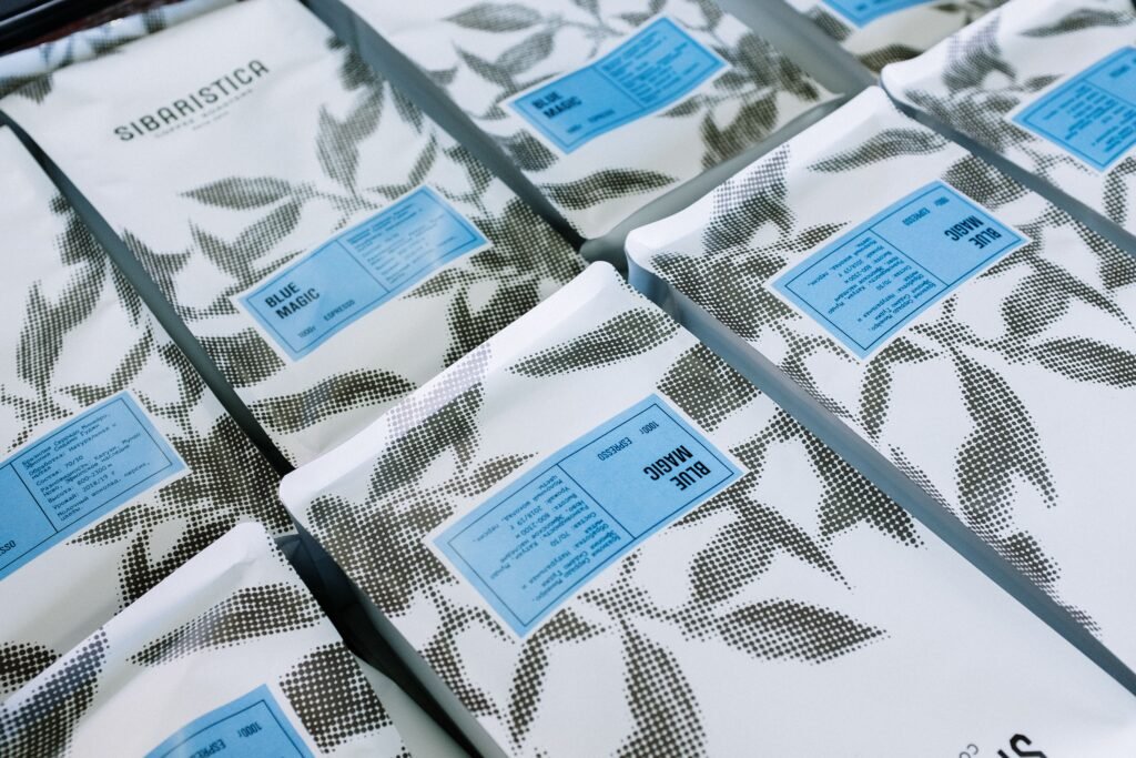 pexels-photo-4829083-4829083 Close-up of branded coffee packages with artistic black and white leaf pattern.